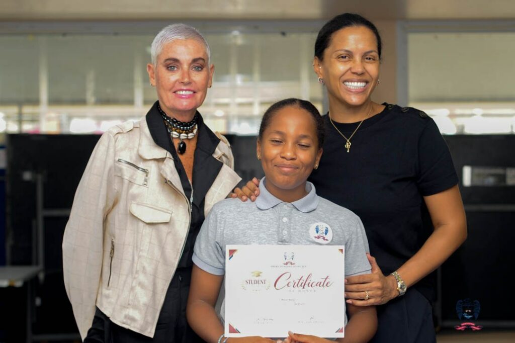 Young ASD student celebrates receiving a certificate alongside members of the school community during October awards.