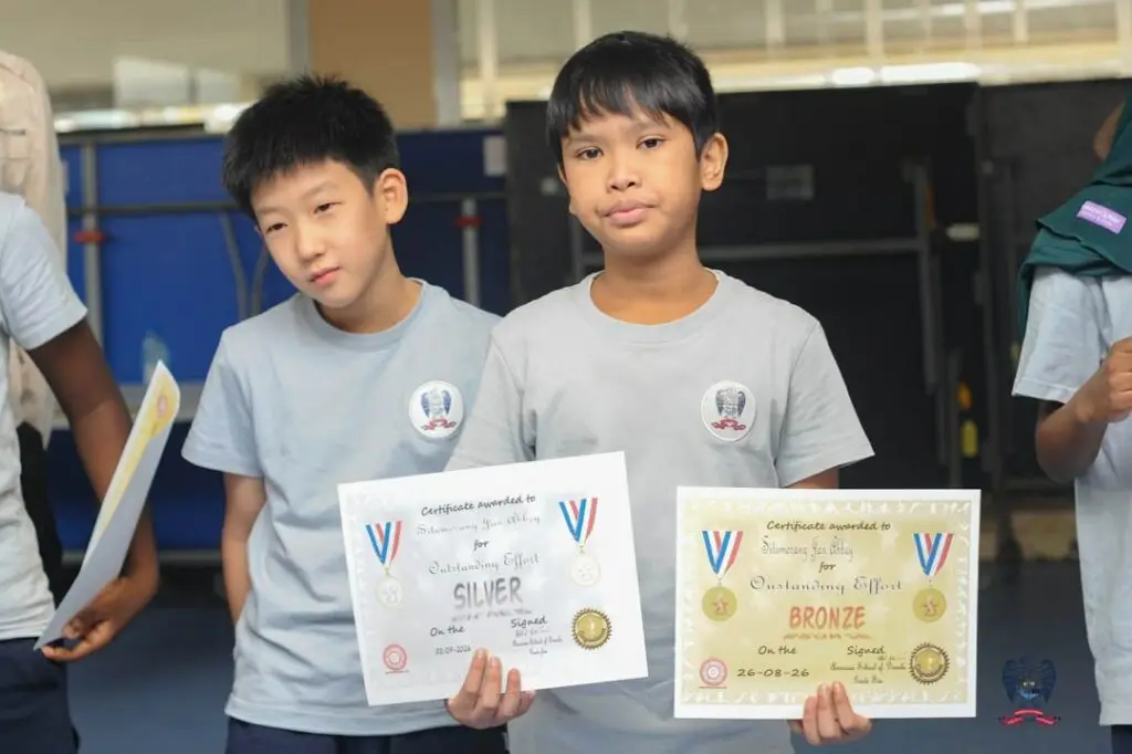 Two American School of Douala students display their certificates during the October Student of the Month celebration.