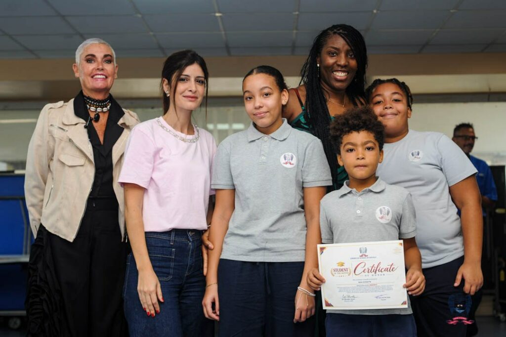merican School of Douala students and adults celebrate October Student of the Month awards with certificates.