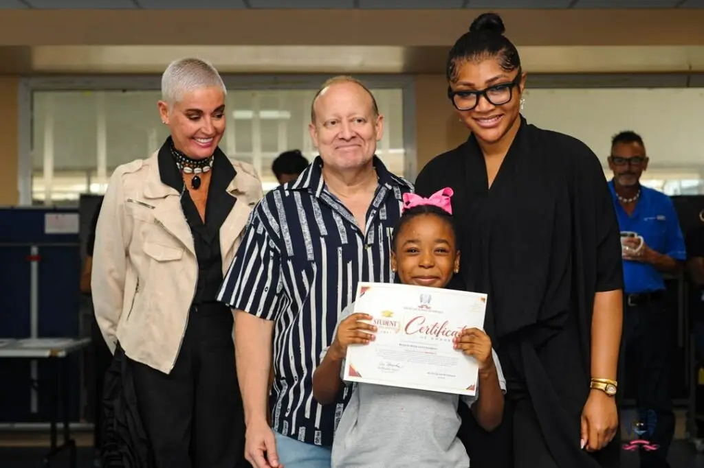 ASD students display their achievement certificates alongside adults during the October Student of the Month celebration.