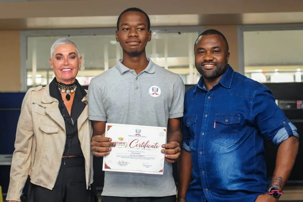 Young American School of Douala student proudly holds a certificate recognizing achievement during October Student of the Mon